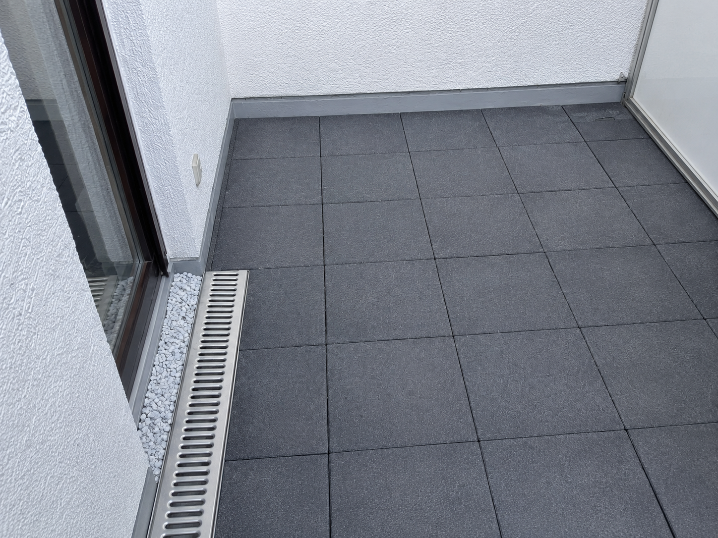 Fertig sanierter Balkon mit Plattenbelag, Entwässerungsrinne und sauber ausgeführtem Anschlussbereich